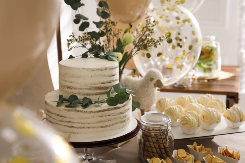 Beautiful cake and other treats on table in room. Sweet buffet