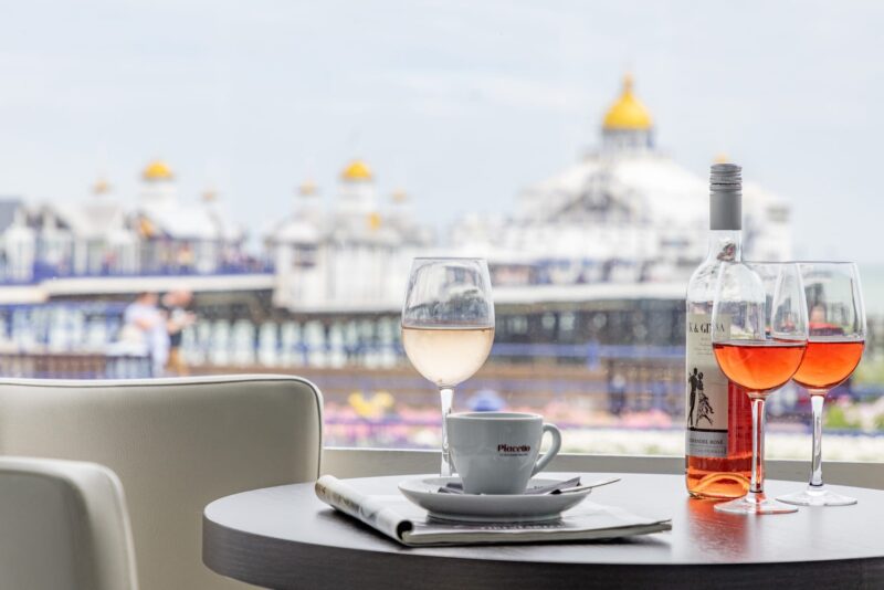 A Bottle Of Wine And Glasses On A Table By A Window