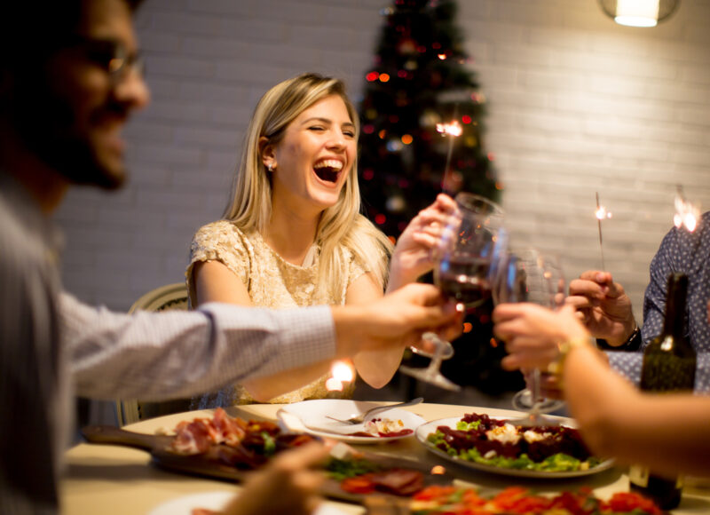 Young people celebrating New Year and drinking red wine
