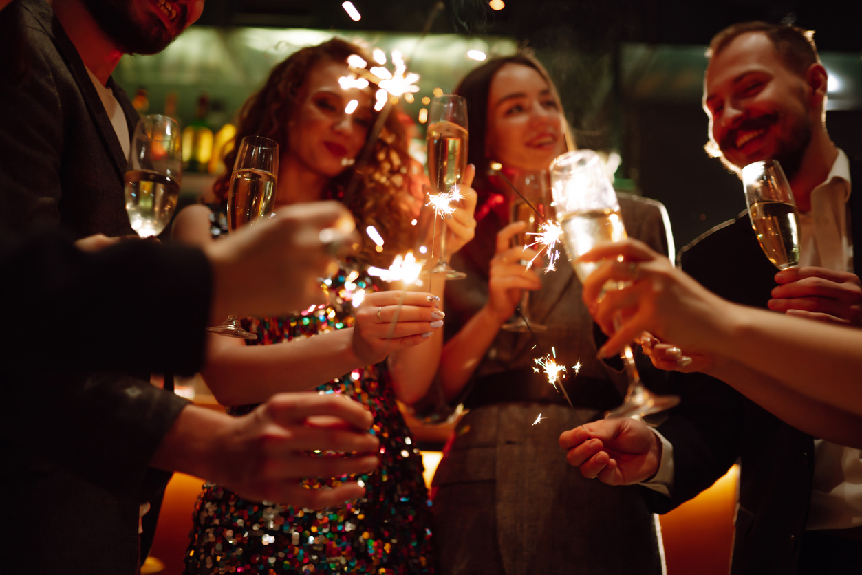 Sparkling sparklers in the hands. Playing firework to celebrate winter holidays with friends at the party.