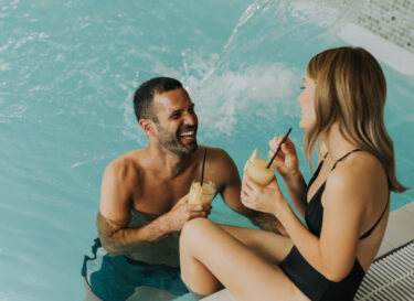 Young couple relaxing by the indoor swimming pool