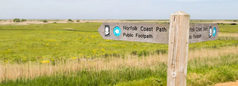 Norfolk Coast Public Footpath Sign in front of rolling fields