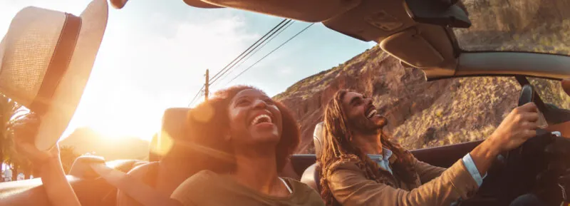 Youn couple smiling and driving