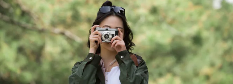 Female tourist taking photos by pine forest – stock photo